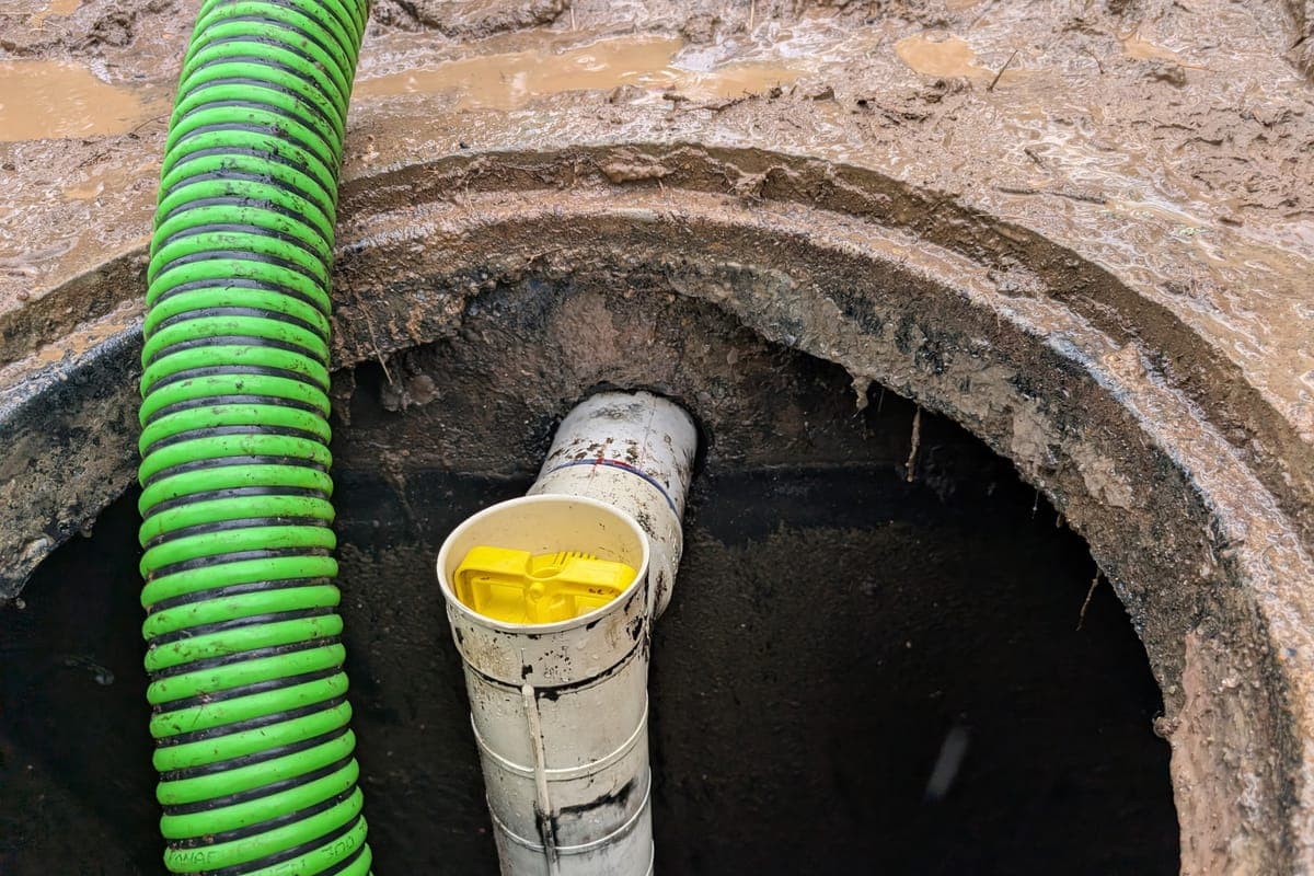 Open septic tank at the lid showing the outlet tee and effluent filter